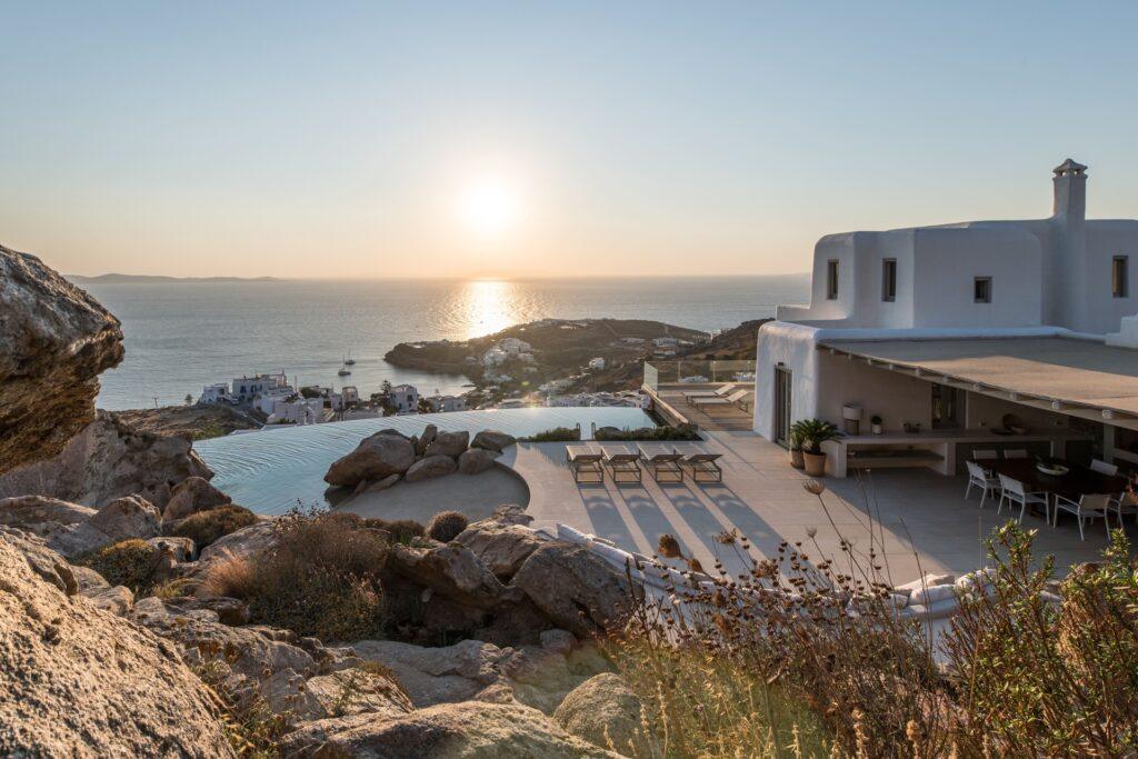 outdoor dining terrace with pool and sea views at Villa Nema, Mykonos